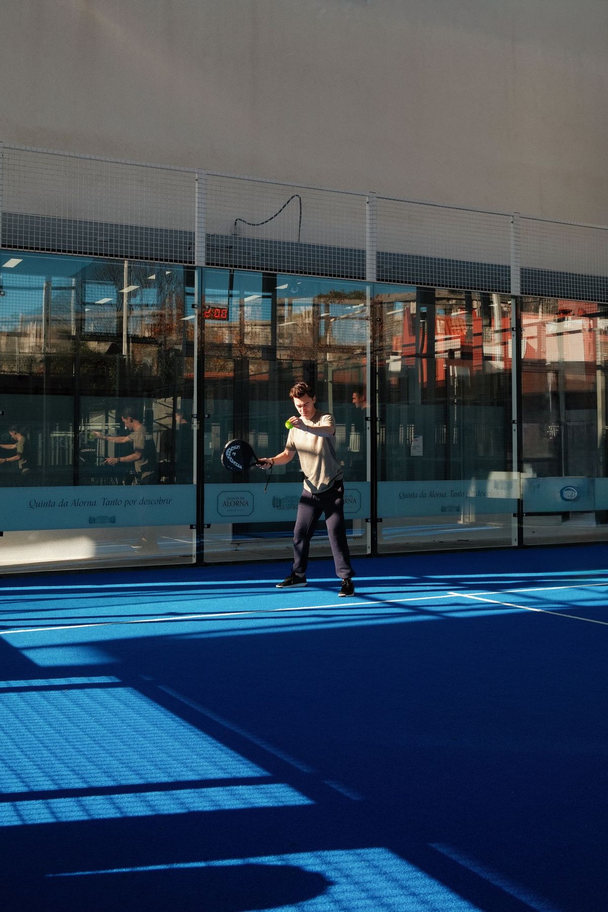Padel players mid-rally on a blue court
